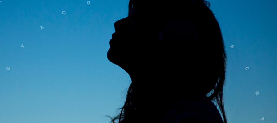 Silhouette of a person in front of blue background